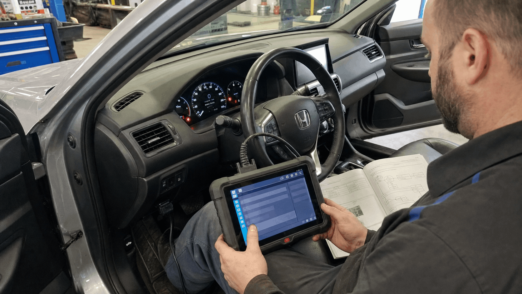 technician performing srs reset using diagnostic scan tool inside car