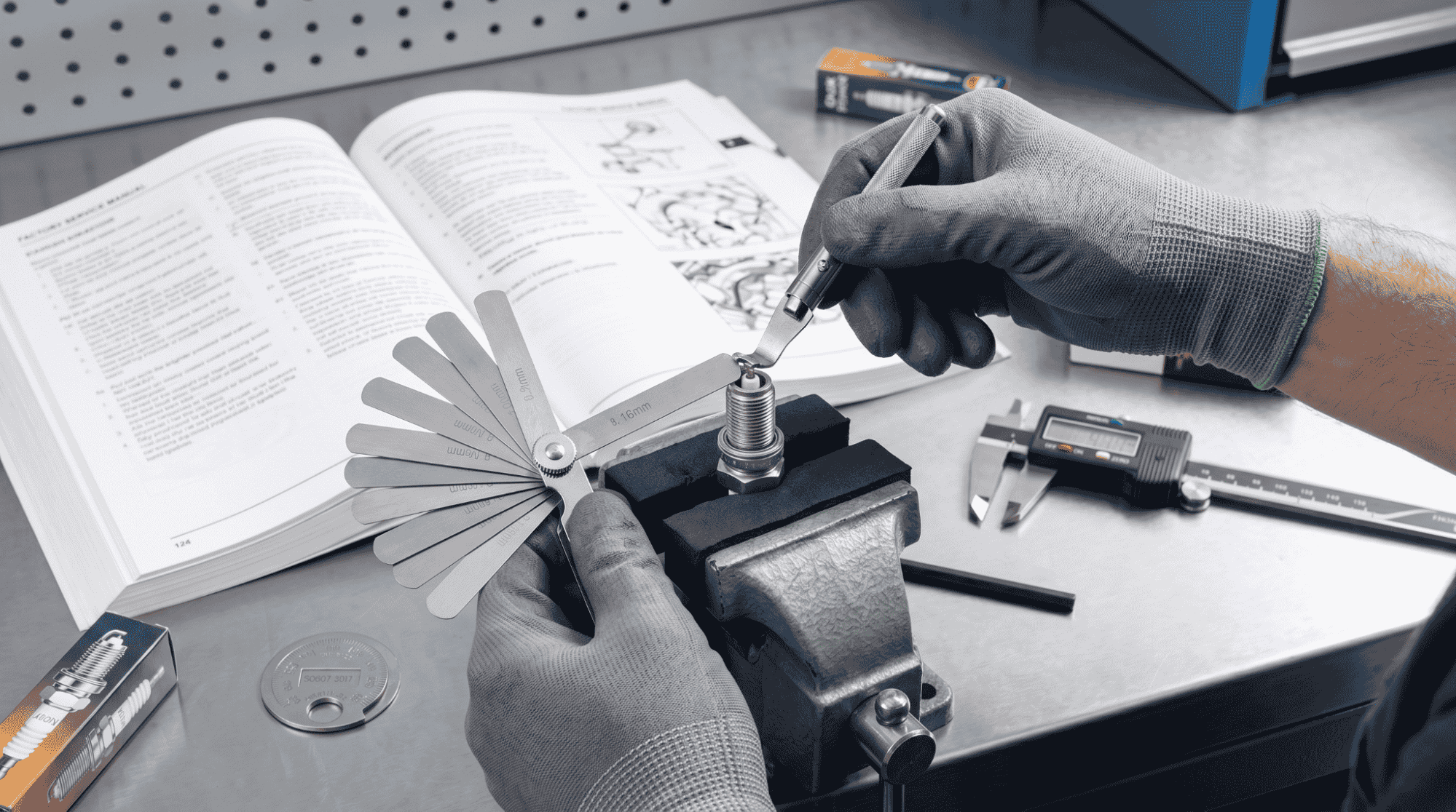 technician precisely adjusting spark plug gap with feeler gauge
